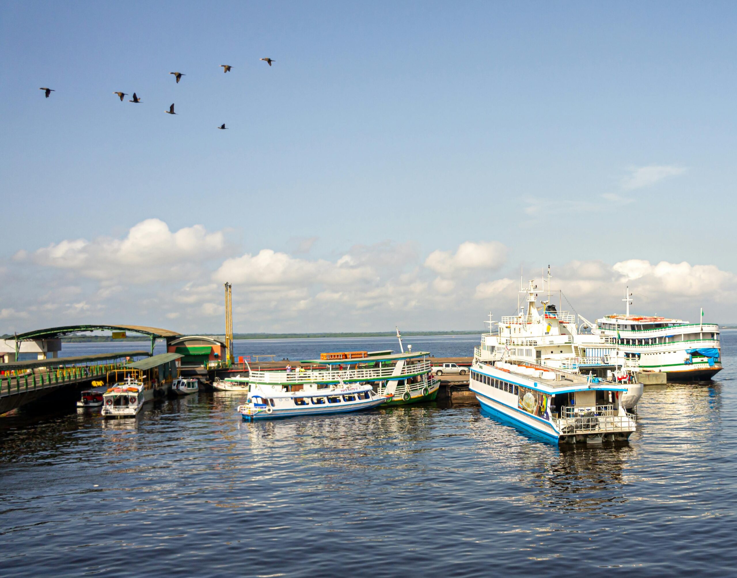 Scenic view of boats docked at a busy harbor in Manaus, Brazil with clear blue skies.