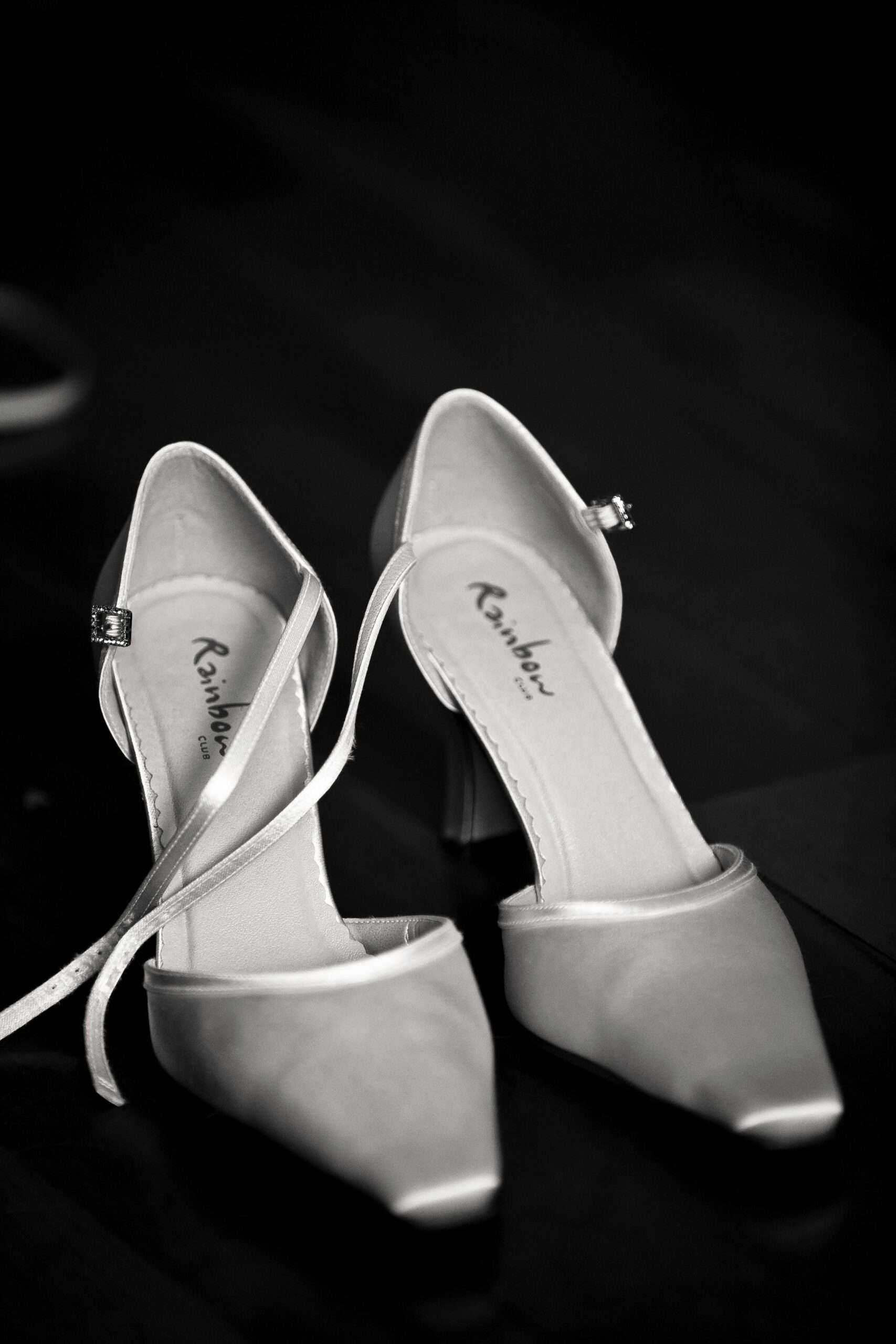 Black and white image of elegant high heel shoes on a dark background.
